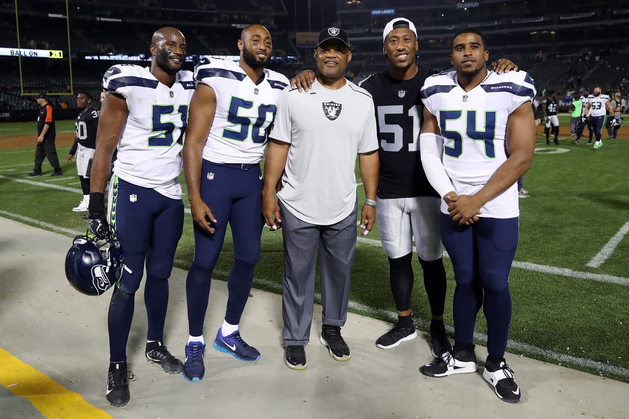 (L-R) Seattle Seahawks linebacker Mike Morgan (51), Seattle Seahawks outside linebacker K.J. Wright (50), Oakland Raiders defensive coordinator Ken Norton, Jr., Oakland Raiders outside linebacker Bruce Irvin (51), and Seattle Seahawks middle linebacker Bobby Wagner (54) smile as they pose for a group photo after the 2017 NFL week 4 preseason football game against the Seattle Seahawks, Thursday, Aug. 31, 2017 in Oakland, Calif. The Seahawks won the game 17-13. (Paul Spinelli via AP)