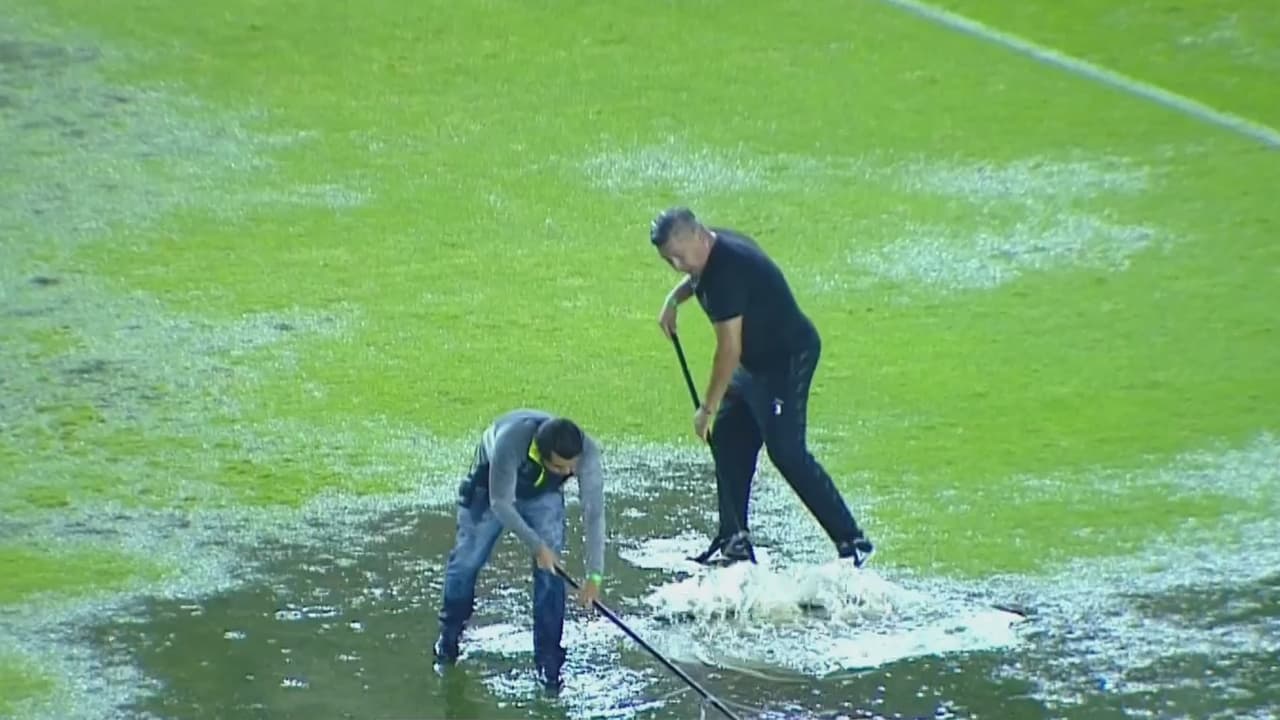 Ayudantes tratan de sacar con celeridad el agua de la cancha de León