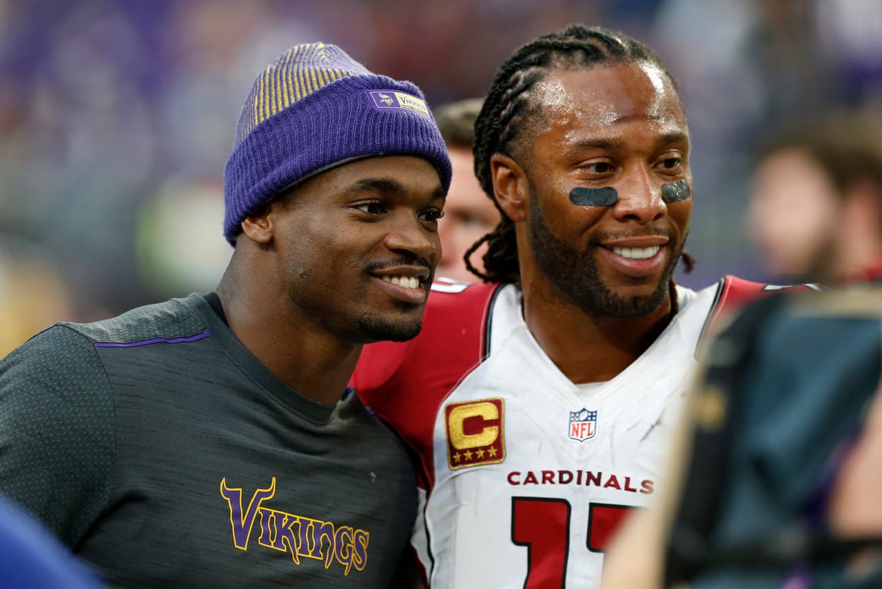 Minnesota Vikings running back Adrian Peterson, left, talks with Arizona Cardinals wide receiver Larry Fitzgerald, right, after an NFL football game Sunday, Nov. 20, 2016, in Minneapolis. The Vikings won 30-24. (AP Photo/Jim Mone)