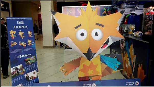 La mascota es de color amarillo y naranja, con un brazo azul y una pierna roja, ambos colores presentes en la bandera chilena.