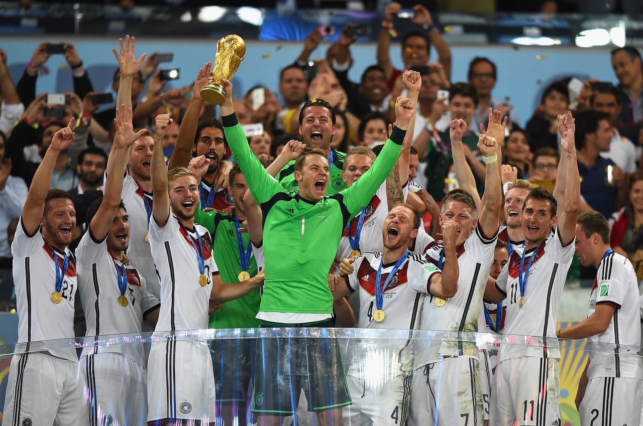 RIO DE JANEIRO, BRAZIL - JULY 13: Manuel Neuer of Germany lifts the World Cup trophy with his team after defeating Argentina 1-0 in extra time during the 2014 FIFA World Cup Brazil Final match between Germany and Argentinaat Maracana on July 13, 2014 in Rio de Janeiro, Brazil. (Photo by Laurence Griffiths/Getty Images)
