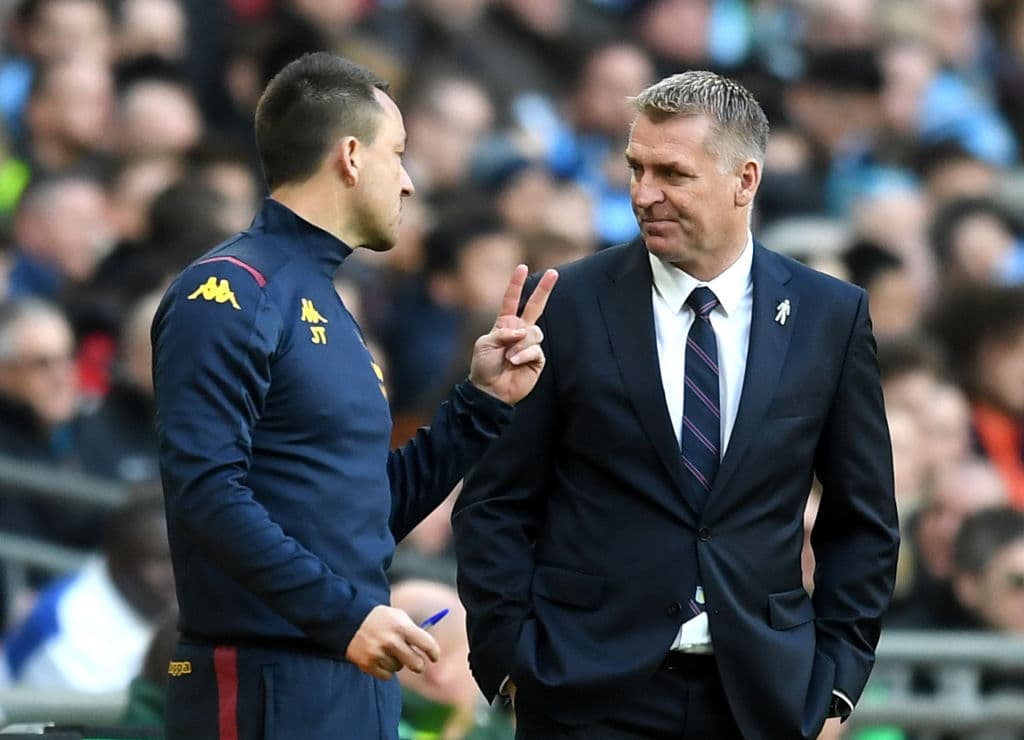 John Terry platica con Dean Smith sobre cómo debe ser la marca en el terreno de juego.