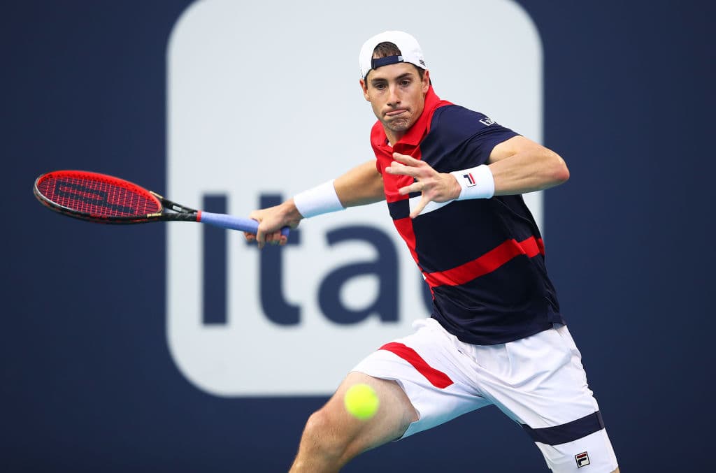 MIAMI GARDENS, FLORIDA - MARCH 27: John Isner of USA in action against Roberto Bautista Agut of Spain during day ten at the Miami Open tennis on March 27, 2019 in Miami Gardens, Florida. (Photo by Julian Finney/Getty Images)