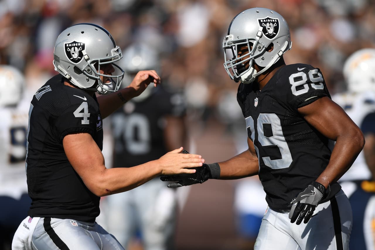 OAKLAND, CA - OCTOBER 09: Derek Carr #4 of the Oakland Raiders celebrates with Amari Cooper #89 after a scoring on a two-point conversion against the San Diego Chargers during their NFL game at Oakland-Alameda County Coliseum on October 9, 2016 in Oakland, California. (Photo by Thearon W. Henderson/Getty Images)