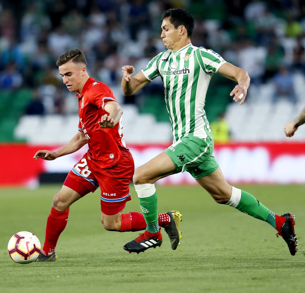 El defensa francés del Real Betis, Aissa Mandi (der), persigue al defensa del Espanyol Adriá Pedrosa (izq) durante el partido correspondiente a la 35 jornada de Liga, disputado en el Estadio Benito Villamarín.