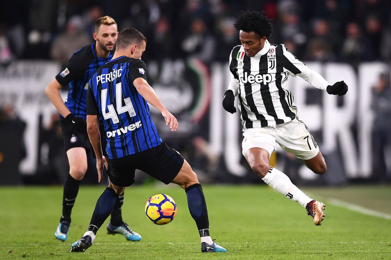 Inter Milan's Croatian forward Ivan Perisic (L) fights for the ball with Juventus' Colombia midfielder Juan Cuadrado (R) during the Italian Serie A football match between Juventus and Inter Milan at The 'Allianz Stadium' in Turin on December 9, 2017. / AFP PHOTO / MARCO BERTORELLO