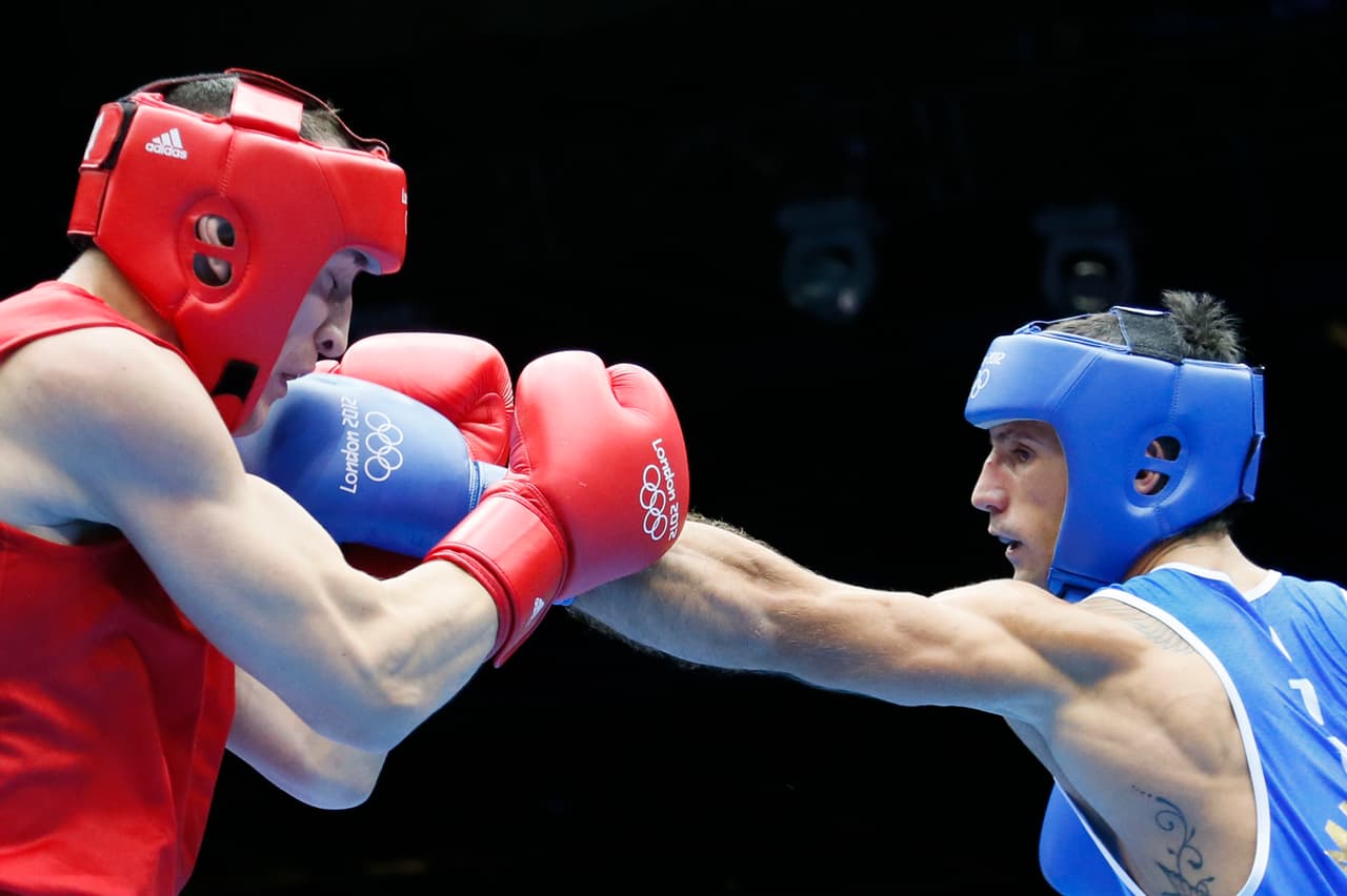 Gyula Kate (L) of Hungary defends against Vincenzo Mangiacapre (R) of Italy during their round of 16 Light-Welterweight (64kg) match of the London 2012 Olympic Games at the ExCel Arena on August 4, 2012 in London. Mangiacapre was awarded a 20-14 points decision. AFP PHOTO / Jack GUEZ (Photo credit should read JACK GUEZ/AFP/GettyImages)