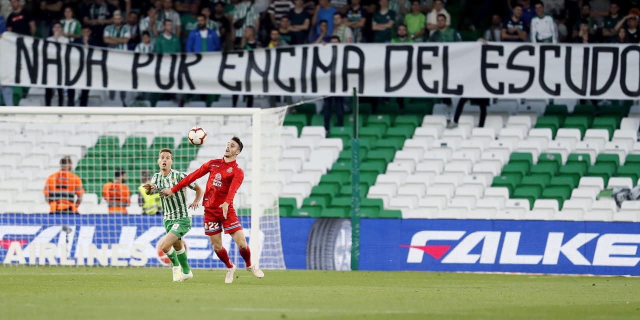 Los ultras del Betis mantienen los asientos vacíos en el primer tiempo en protesta por el mal paso del equipo mientras Sergio Canales (izq), del Betis, y Mario Hermoso, del Espanyol, disputan un balón durante el partido correspondiente a la 35 jornada de La Liga, disputado el Estadio Benito Villamarín.