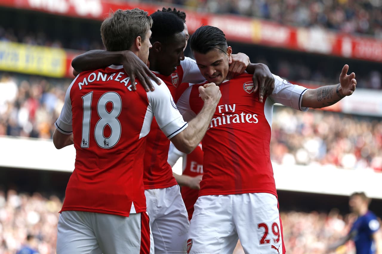 Arsenal's Swiss midfielder Granit Xhaka (R) celebrates with Arsenal's Spanish defender Nacho Monreal (L) and Arsenal's English striker Danny Welbeck (C) after scoring the opening goal of the English Premier League football match between Arsenal and Manchester United at the Emirates Stadium in London on May 7, 2017. Arsenal won the game 2-0. / AFP PHOTO / IKIMAGES / Ian KINGTON / RESTRICTED TO EDITORIAL USE. No use with unauthorized audio, video, data, fixture lists, club/league logos or 'live' services. Online in-match use limited to 45 images, no video emulation. No use in betting, games or single club/league/player publications. / (Photo credit should read IAN KINGTON/AFP/Getty Images)