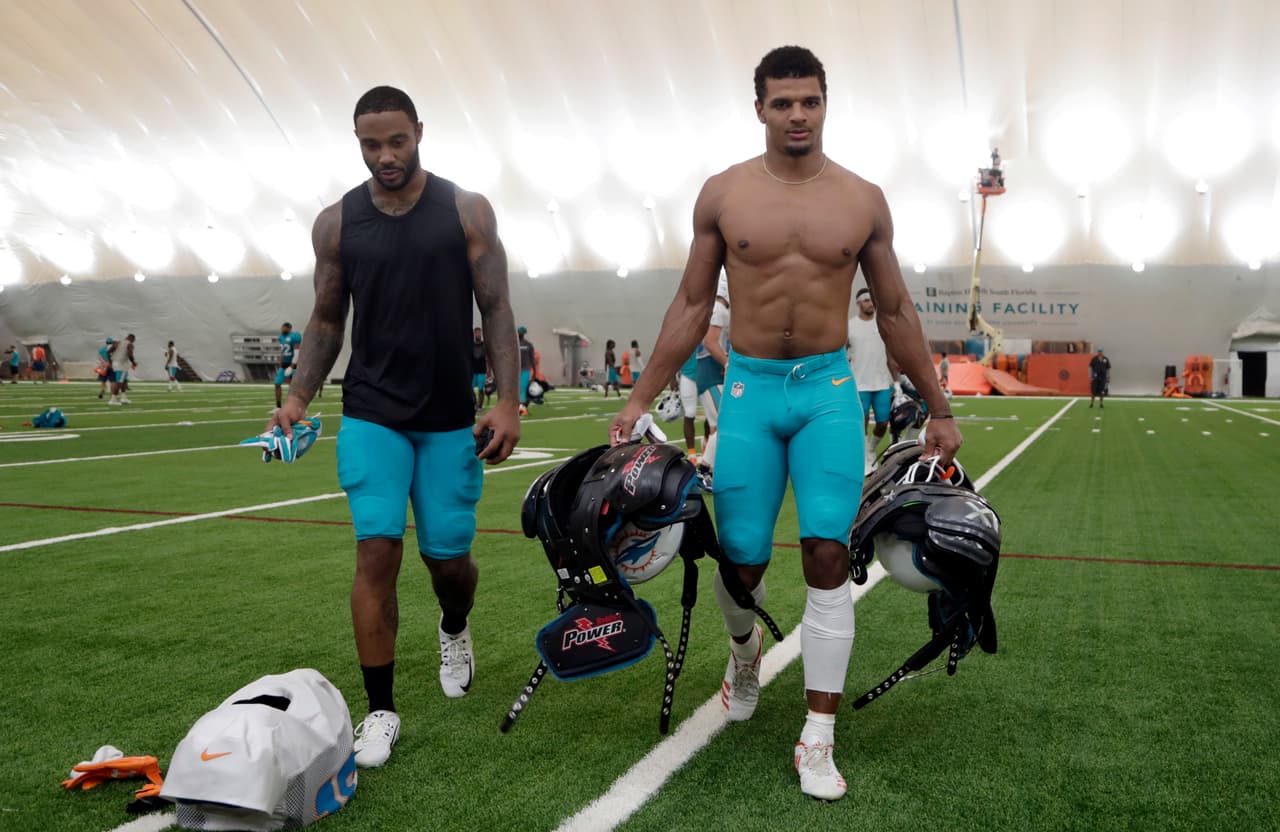 El defensivo secundario de los Miami Dolphins Minkah Fitzpatrick, derecha, sale del campo de práctica luego del entrenamiento del equipo en sus instalaciones ubicadas en Davie, Florida.