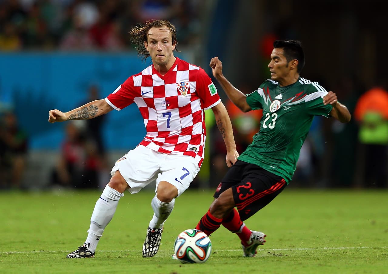 RECIFE, BRAZIL - JUNE 23: Ivan Rakitic of Croatia and Jose Juan Vazquez of Mexico compete for the ball during the 2014 FIFA World Cup Brazil Group A match between Croatia and Mexico at Arena Pernambuco on June 23, 2014 in Recife, Brazil. (Photo by Michael Steele/Getty Images)