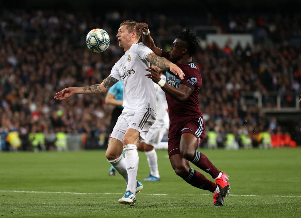 El mediocampista alemán, Toni Kroos, se queda con el balón pese a la marca de Joseph Aidoo que lo empuja y lo aprieta pero sin éxito.