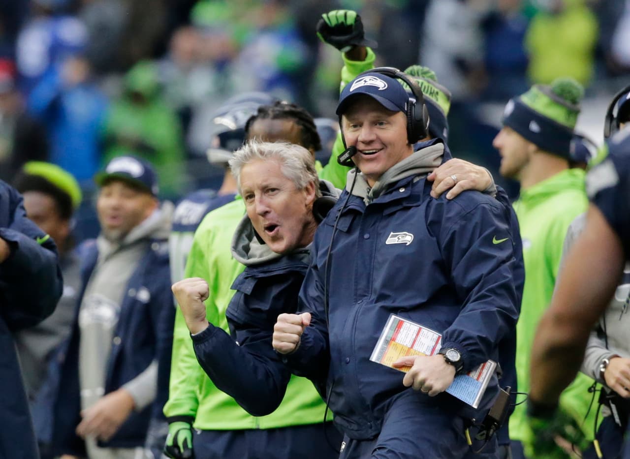 Seattle Seahawks head coach Pete Carroll, left, and offensive coordinator Darrell Bevell, right, react after Seahawks wide receiver Doug Baldwin passed to quarterback Russell Wilson for a touchdown against the Philadelphia Eagles in the second half of an NFL football game, Sunday, Nov. 20, 2016, in Seattle. (AP Photo/John Froschauer)