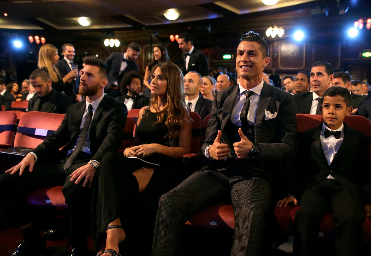 El portugués Cristiano Ronaldo, segundo de derecha a izquierda, y su hijo Cristiano Ronaldo Jr., derecha, presencian el evento sentados al lado del astro argentino Lionel Messi, izquierda, y su esposa Antonella durante la entrega de premios The Best de FIFA 2017, en el Palladium Theatre de Londres, el lunes 23 de octubre de 2017. (AP Foto/Alastair Grant)
