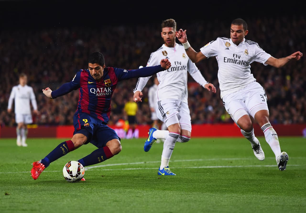 BARCELONA, SPAIN - MARCH 22: Luis Suarez of Barcelona shoots past Sergio Ramos and Pepe of Real Madrid CF to score their second goal during the La Liga match between FC Barcelona and Real Madrid CF at Camp Nou on March 22, 2015 in Barcelona, Spain. (Photo by David Ramos/Getty Images)