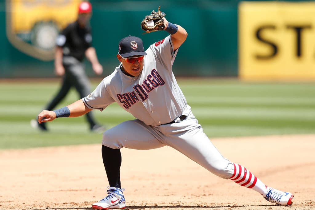 El tercera base mexicano de los San Diego Padres Cristian Villanueva, con medias y uniforme especial, mientras hace un gran lance en la esquina caliente ante los Oakland Athletics en Oakland Coliseum.