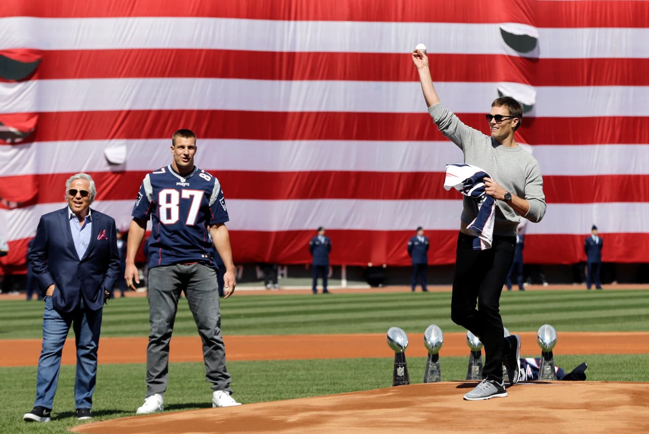 New England Patriots quarterback Tom Brady throws the ceremonial first pitch as owner Robert Kraft and tight end Rob Gronkowski (87) watch during Boston Red Sox Home Opening Day ceremonies at Fenway Park, Monday, April 3, 2017, in Boston. The Red Sox face the Pittsburgh Pirates in the baseball game. (AP Photo/Elise Amendola)
