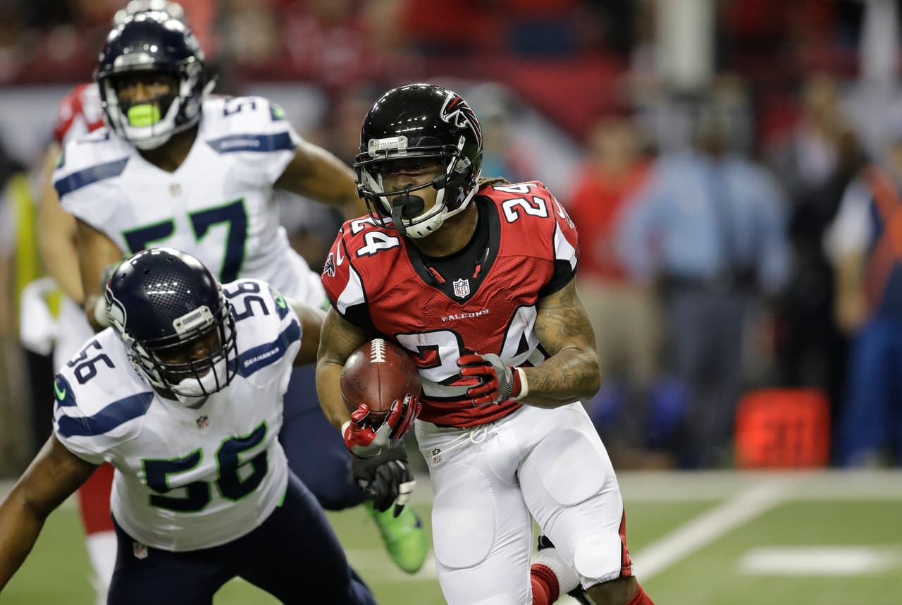 Atlanta Falcons running back Devonta Freeman (24) runs by Seattle Seahawks defensive end Cliff Avril (56) during the first half of an NFL football NFC divisional playoff game, Saturday, Jan. 14, 2017, in Atlanta. (AP Photo/David Goldman)