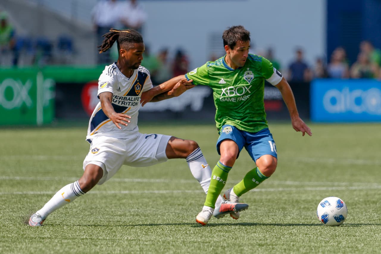 Aug 18, 2018; Seattle, WA, USA; Seattle Sounders FC midfielder Nicolas Lodeiro (10) holds off Los Angeles Galaxy forward Bradford Jamieson IV (38) during the second half at CenturyLink Field. Mandatory Credit: Jennifer Buchanan-USA TODAY Sports