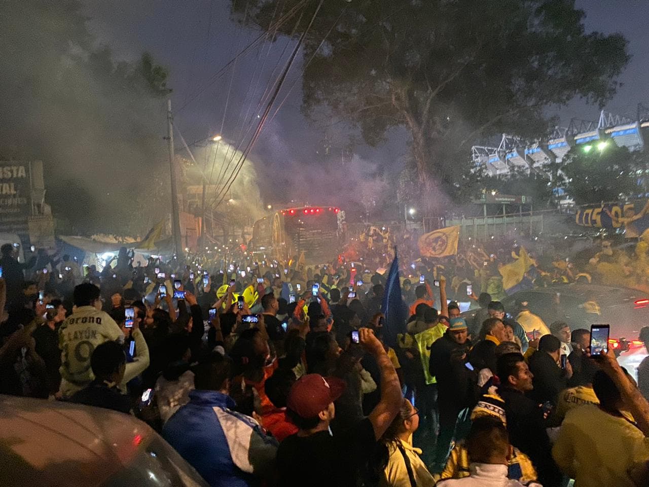 ¡Gran recibimiento al América! La afición le muestra el apoyo a su equipo con cantos, banderas y bengalas a su llegada al Estadio Azteca.