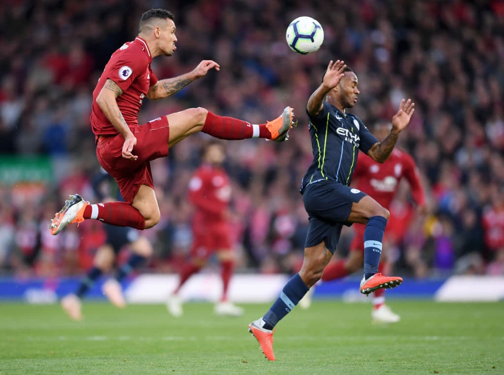 LIVERPOOL, ENGLAND - OCTOBER 07: Dejan Lovren of Liverpool jumps for the ball under pressure from Raheem Sterling of Manchester City during the Premier League match between Liverpool FC and Manchester City at Anfield on October 7, 2018 in Liverpool, United Kingdom. (Photo by Laurence Griffiths/Getty Images)