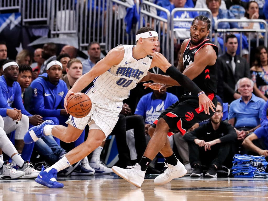 Aaron Gordon (00) del Orlando Magic busca superar a Kawhi Leonard de los Toronto Raptors.
