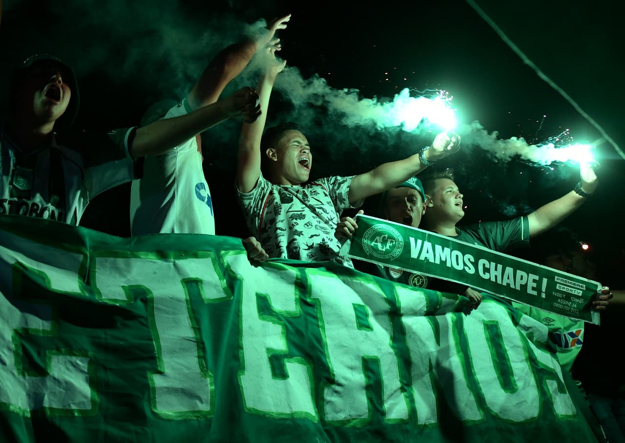People attend a ceremony in honour of the victims and survivors of Lamia flight 2933 on the first anniversary of the plane crash in Colombia that wiped out Brazilian football club Chapecoense, at the Arena Conda stadium in Chapeco, Santa Catarina, Brazil on November 28 2017. The plane was flying Chapecoense to Medellin to take on Atletico Nacional in the Copa Sudamericana finals -- the biggest and most unexpected game in the Brazilian team's history. When the plane ran out of fuel and went down in inhospitable mountains near its destination 71 of the 77 aboard died including 19 players. / AFP PHOTO / NELSON ALMEIDA (Photo credit should read NELSON ALMEIDA/AFP/Getty Images)