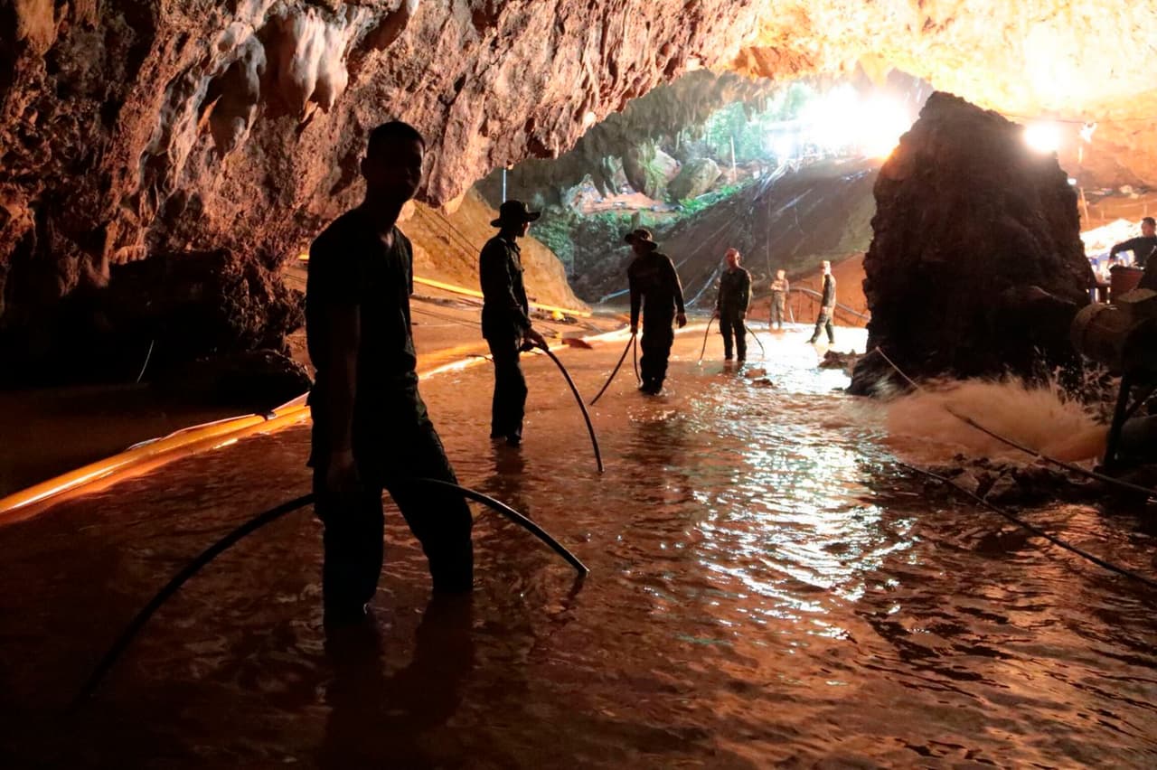 Equipos de rescate trabajan en un sistema de bombeado de agua en la entrada de la cueva en la que están atrapados doce niños en Mae Sai, Tailandia. La imagen sin fecha fue distribuida por la Marina tailandesa.
