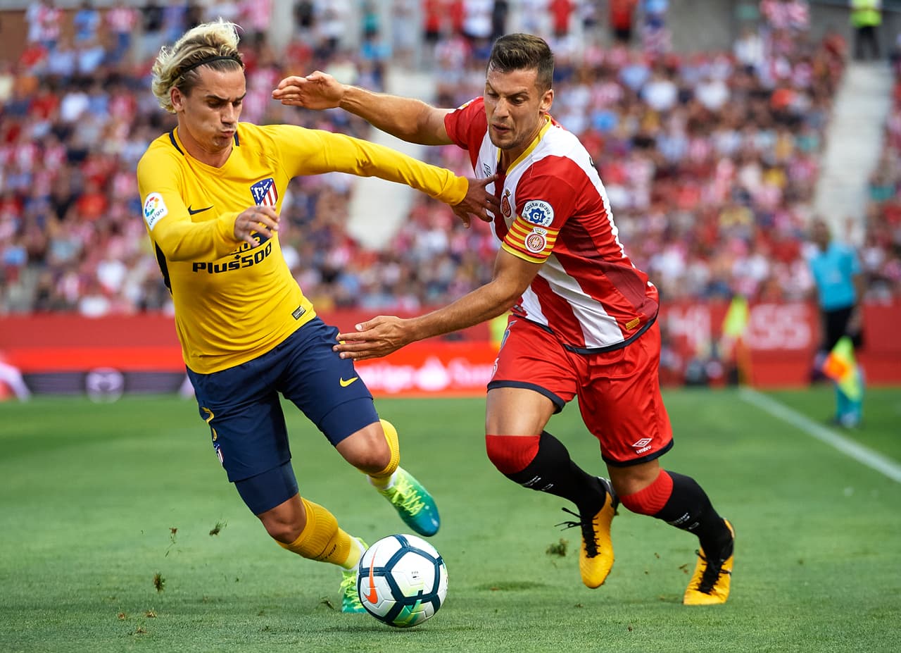 GIRONA, SPAIN - AUGUST 19: Alex Granell of Girona competes for the ball with Antoine Griezmann (L) of Atletico de Madrid during the La Liga match between Girona and Atletico de Madrid at Municipal de Montilivi Stadium on August 19, 2017 in Girona, Spain. (Photo by Manuel Queimadelos Alonso/Getty Images)