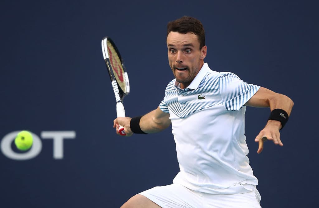 MIAMI GARDENS, FLORIDA - MARCH 27: Roberto Bautista Agut of Spain in action against John Isner of USA during day ten at the Miami Open tennis on March 27, 2019 in Miami Gardens, Florida. (Photo by Julian Finney/Getty Images)