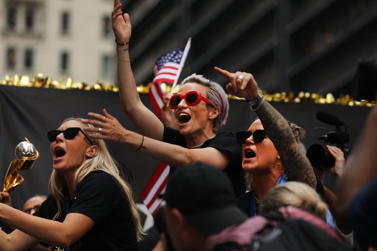 Megan Rapinoe (C) y Ashlyn Harris (R) celebran mientras montan en una carroza durante el Desfile de la Victoria del Equipo Nacional de Fútbol Femenino de Estados Unidos a través del Cañón de los Héroes el 10 de julio de 2019 en la ciudad de Nueva York. El equipo derrotó a Holanda 2-0 el domingo en Francia para ganar la Copa Mundial Femenina de 2019. (Foto de Spencer Platt/Getty Images)