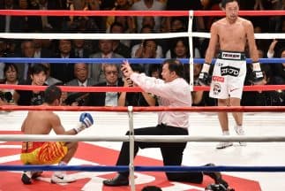 Yamanaka observa a Suriyan Sor Rungvisai en la lona recibiendo la cuenta de protección.