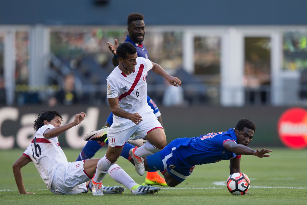 Jeff Louis de Haiti lucha por el balón contra Miguel Trauco y Oscar Vilchez de Perú.