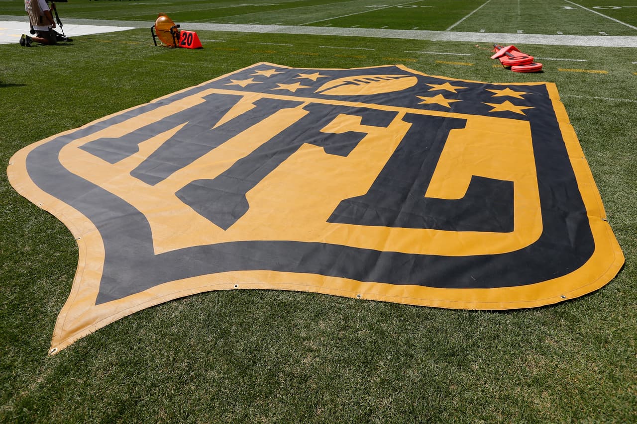 A detail view of a large gold NFL Logo Shield celebrating the 50th anniversary of the Super Bowl is seen on the sidelines during a preseason NFL football game between the Green Bay Packers against the Pittsburgh Steelers on Sunday, August 23, 2015 in Pittsburgh. The Packers defeated the Steelers 24-19. (Scott Boehm via AP)