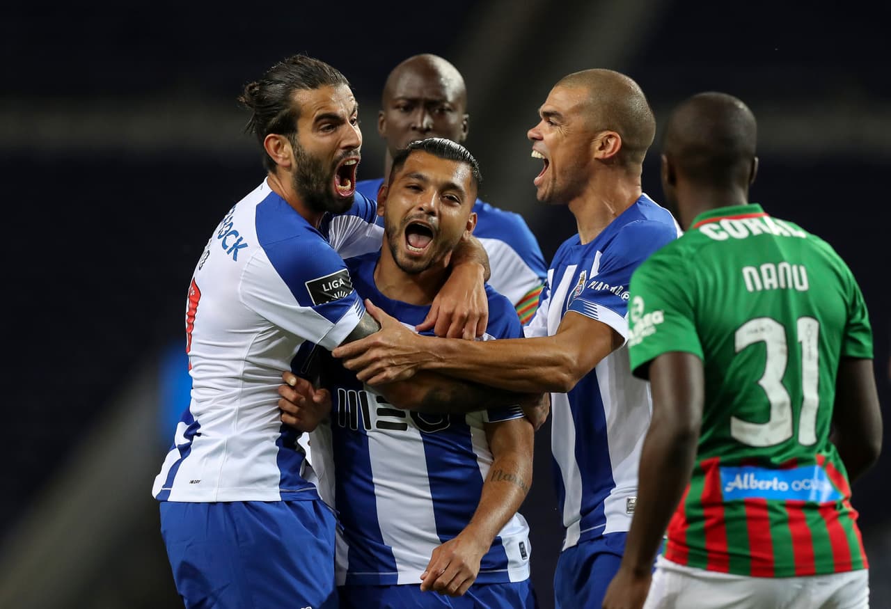 Porto's Tecatito Corona, center, celebrates after scoring the opening goal during the Portuguese League soccer match between FC Porto and Maritimo in Porto, Portugal, Wednesday, June 10, 2020. The Portuguese League soccer matches are being played without spectators because of the coronavirus pandemic. (Jose Coelho/Pool via AP)