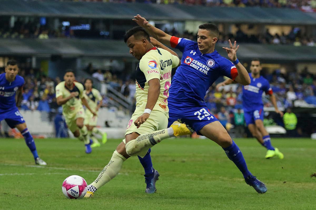 El delantero colombiano Roger Martínez (izquierda) es marcado por el argentino Iván Marcone del Cruz Azul (izquierda).