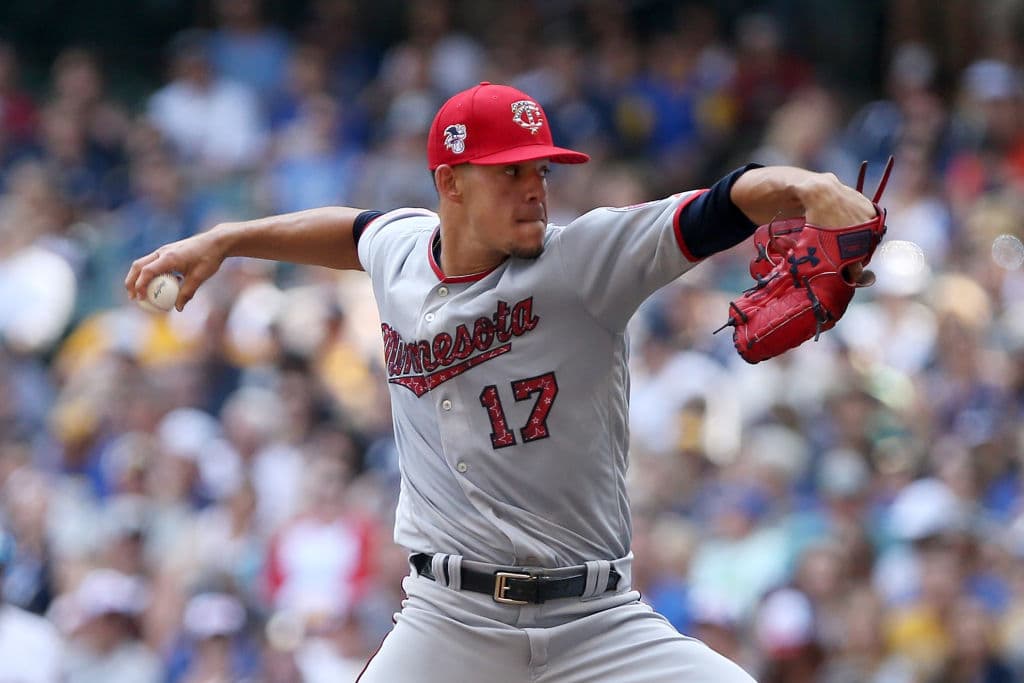 El pitcher puertorriqueño José Berrios de los Minnesota Twins se alista a realizar un lanzamiento en el juego entre su equipo y los Milwaukee Brewers. Su uniforme y gorra lucen detalles alusivos.
