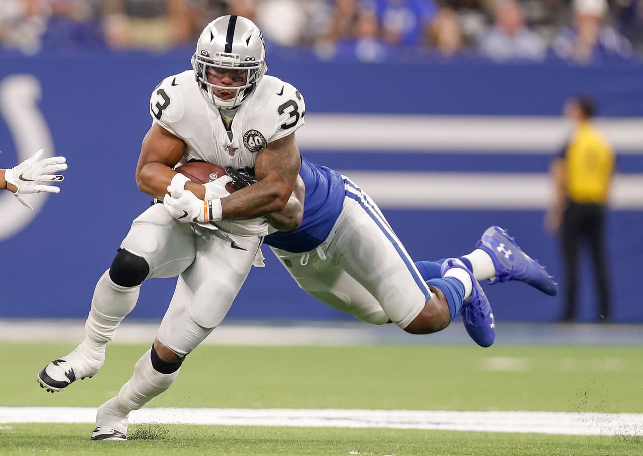 Oakland Raiders 31-24 Indianapolis Colts. DeAndre Washington corre con el balón esquivando a Jihad Ward.
