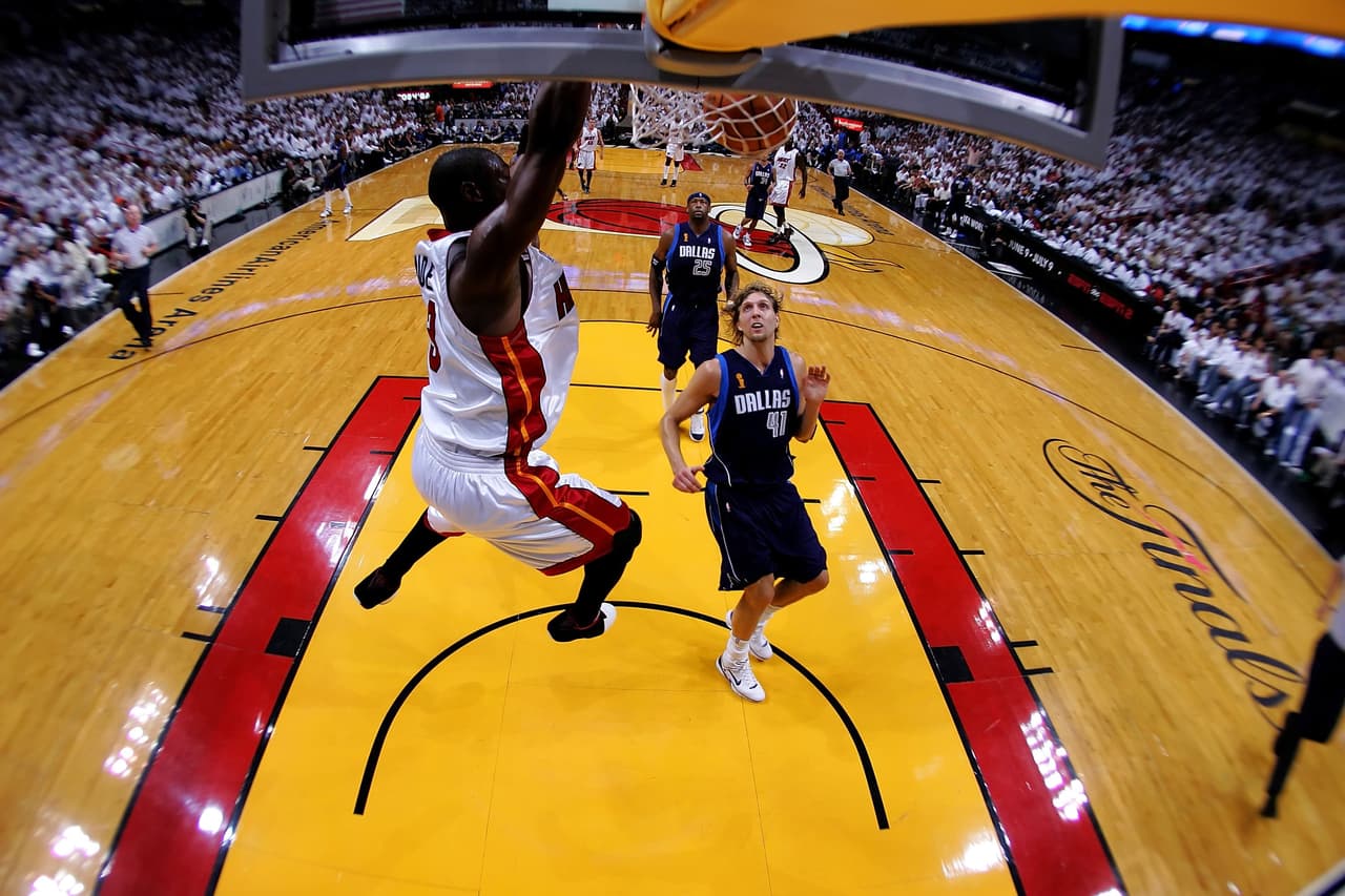MIAMI - JUNE 18: Dwyane Wade #3 of the Miami Heat dunks the ball as Dirk Nowitzki #41 of the Dallas Mavericks looks on in the first quarter of game five of the 2006 NBA Finals on June 18, 2006 at American Airlines Arena in Miami, Florida. NOTE TO USER: User expressly acknowledges and agrees that, by downloading and or using this photograph, User is consenting to the terms and conditions of the Getty Images License Agreement. (Photo by Ronald Martinez/Getty Images)