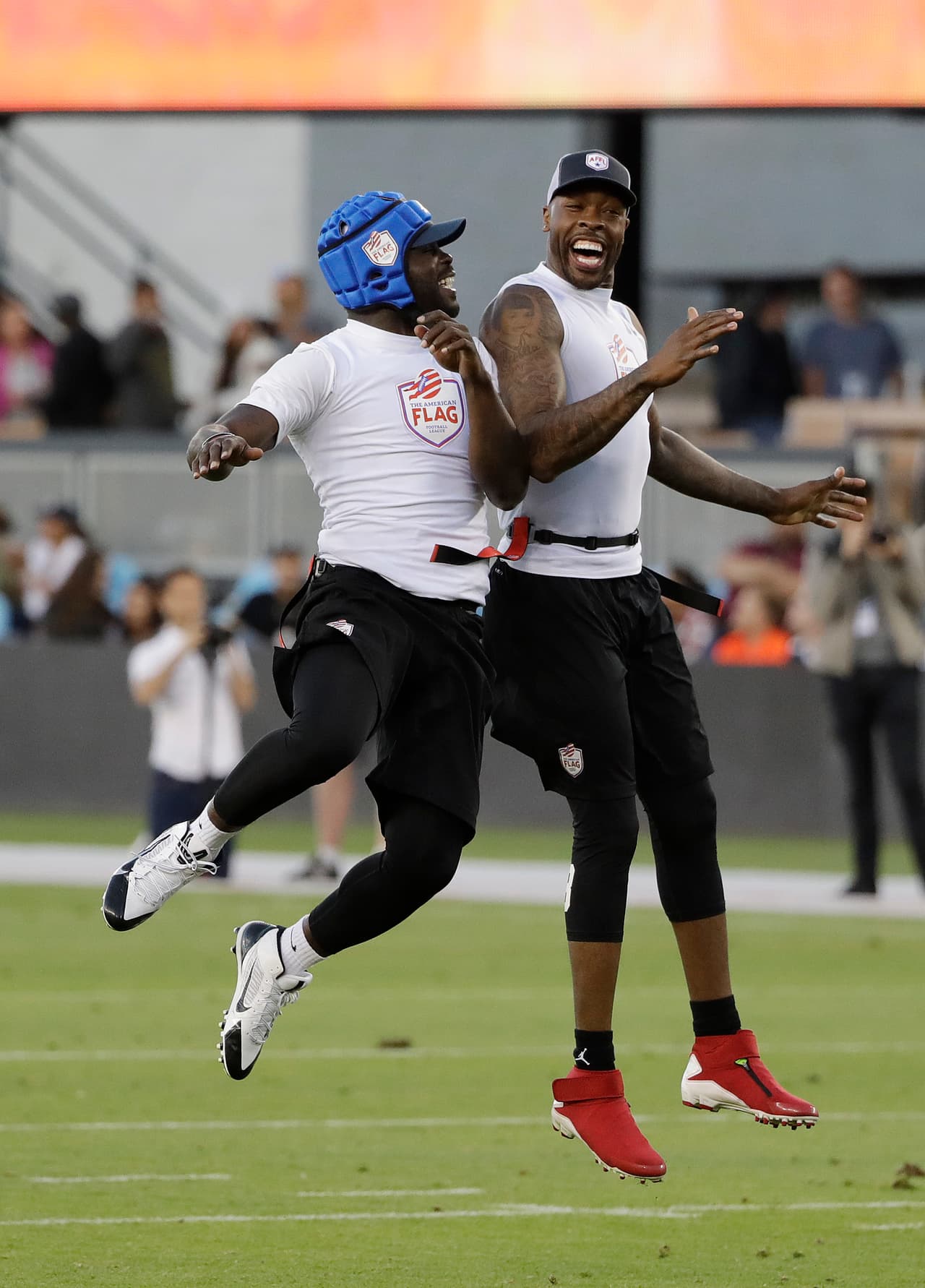 Team Vick's Michael Vick, left, and Dennis Dixon celebrate a touchdown against Team Owens during a flag football exhibition game Tuesday, June 27, 2017, in San Jose, Calif. (AP Photo/Marcio Jose Sanchez)