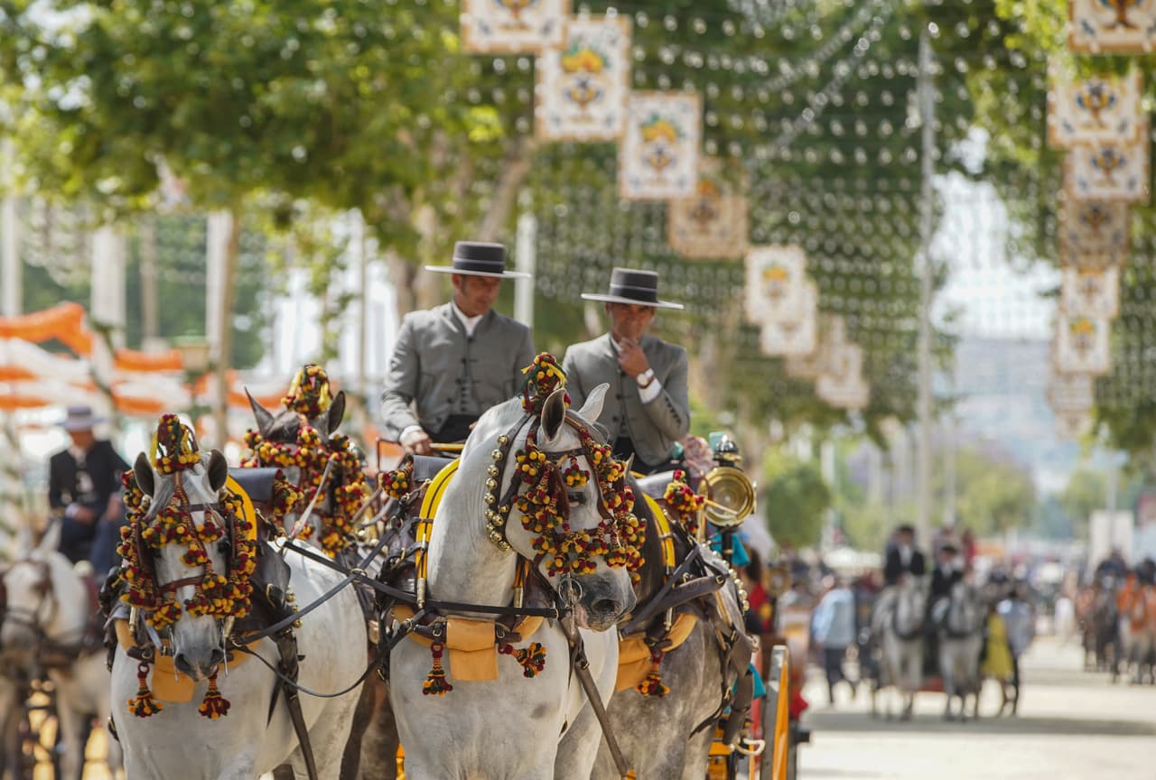 Los carruajes de caballos con los jinetes y sus trajes formales son típicos de la feria de Sevilla.