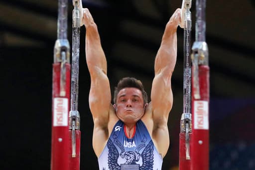 El estadounidense Samuel Mikulak realiza un ejercicio en las barras paralelas durante la final para varones del Campeonato MUndial de Gimnasia en el Aspire Dome.
