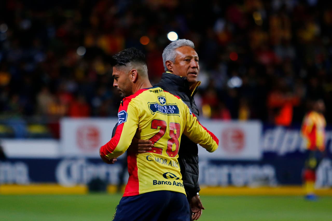 El técnico Roberto Hernández abraza en su despedida a Carlos Morales, quien fue titular y reemplazado al minuto 8 del partido.