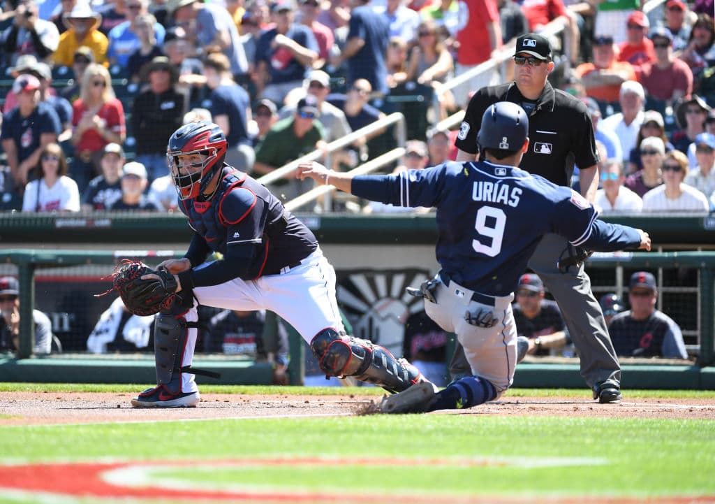 El mexicano Luis Urías de los San Diego Padres se barre enfáticamente en el home plate para vencer el toque del receptor de los Cleveland Indians Roberto Pérez en su partido de pretemporada de este lunes.