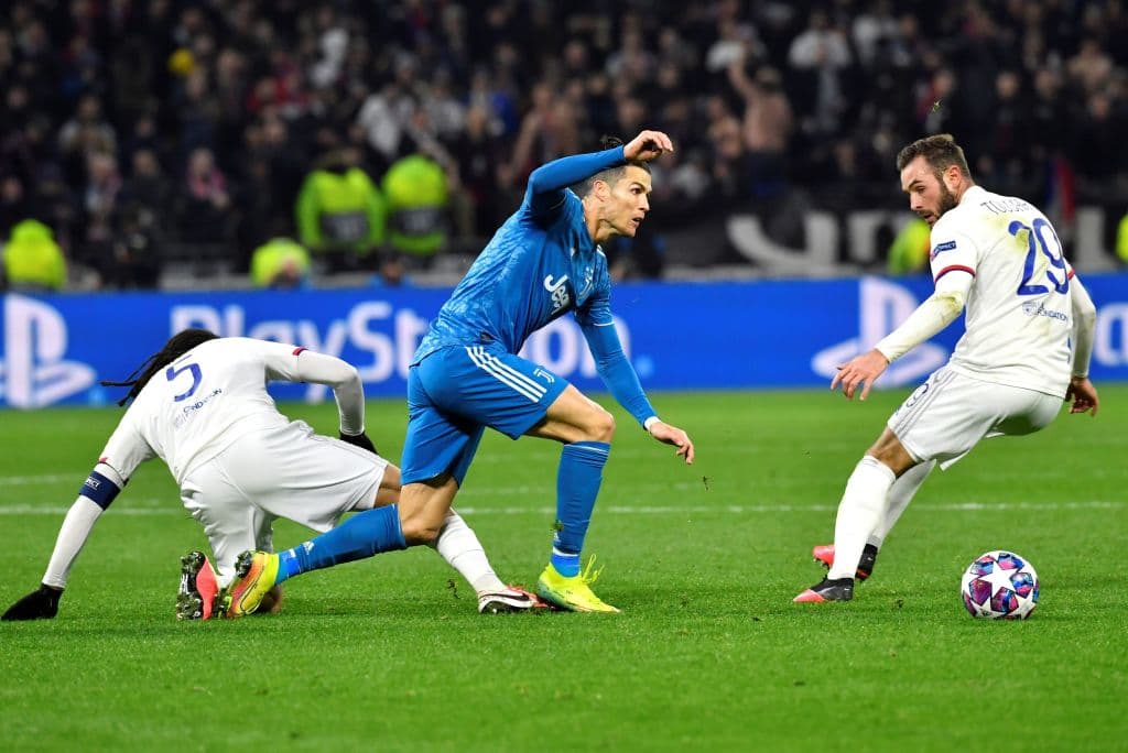 Cristiano Ronaldo pasa sobre Jason Denayer y Lucas Tousart, aunque el primero le alcanza a puntear el balón que se le va de largo.