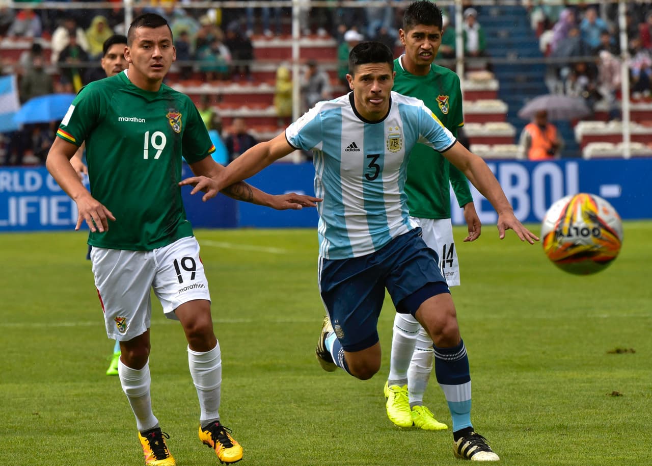 Roncaglia en busca de la pelota por la banda derecha ante la mirada del boliviano Flores.