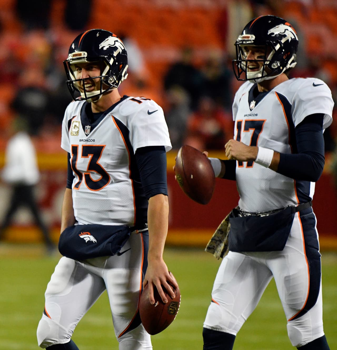 Denver Broncos quarterbacks Brock Osweiler (17) and Trevor Siemian (13) smile as they stand together during warm up before an NFL football game against the Kansas City Chiefs in Kansas City, Mo., Monday, Oct. 30, 2017. (AP Photo/Ed Zurga)