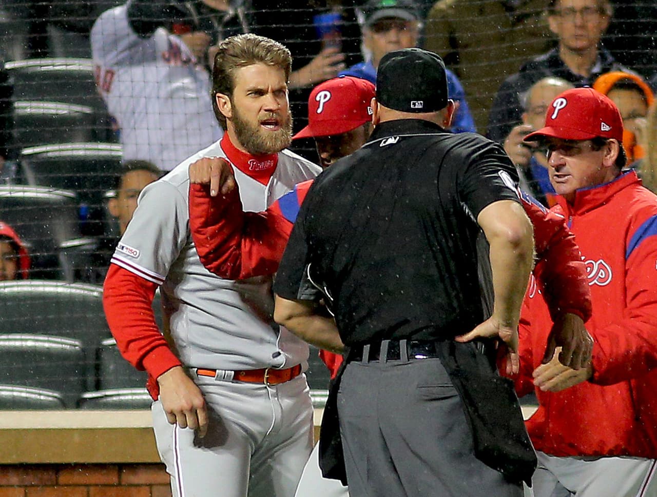 El estelar outfielder de los Philadelphia Phillies, quien firmó un pacto de 10 temporadas y 300 millones de dólares, estaba en el dugout y gritándole al umpire que dos lanzamientos los consideraba altos para ser marcados strike.