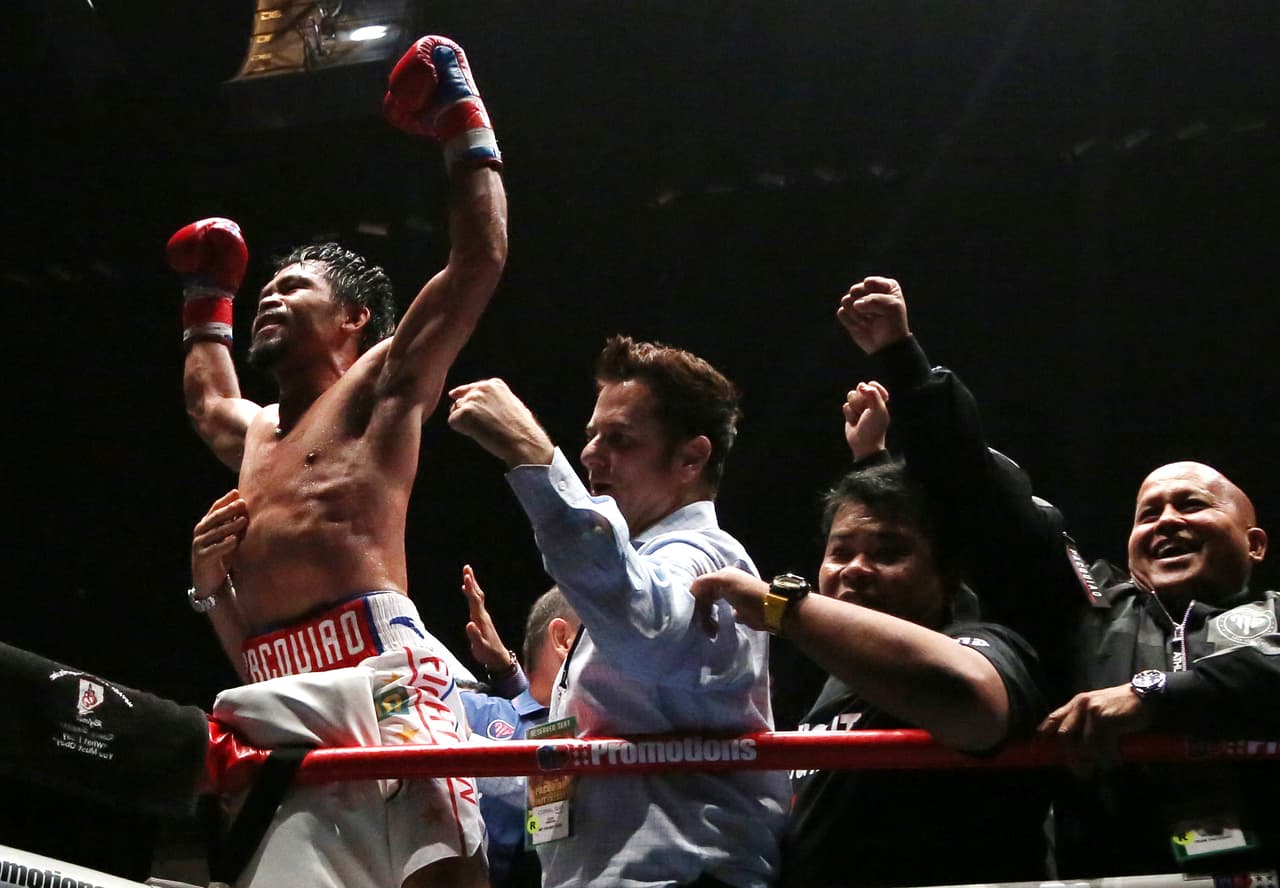 Manny Pacquiao of the Philippines, left, celebrates after defeating Lucas Matthysse of Argentina during their WBA World welterweight title bout in Kuala Lumpur, Malaysia, Sunday, July 15, 2018. Filipino boxing legend Pacquiao clinched his 60th victory Sunday with a seventh-round knockout of Matthysse, his first stoppage in nine years, that will help revive his career.(AP Photo/Yam G-Jun)