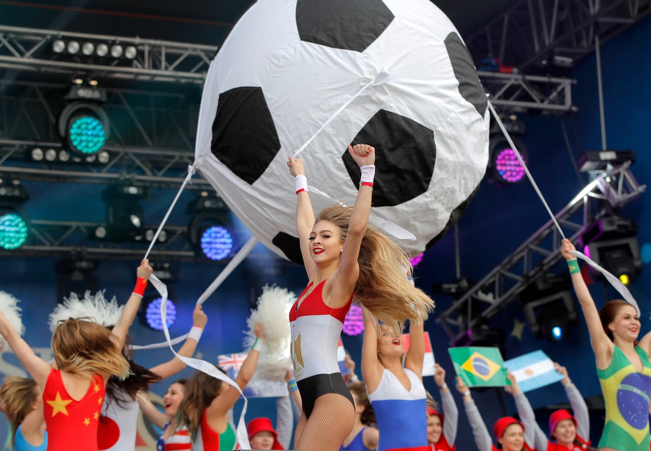 Dancers wearing costumes in the flag colors of the participating nations perform before the opening match of the 2018 soccer World Cup, between Russia and Saudi Arabia, in the fan zone in Yekaterinburg, Russia, Thursday, June 14, 2018. (AP Photo/Vadim Ghirda)